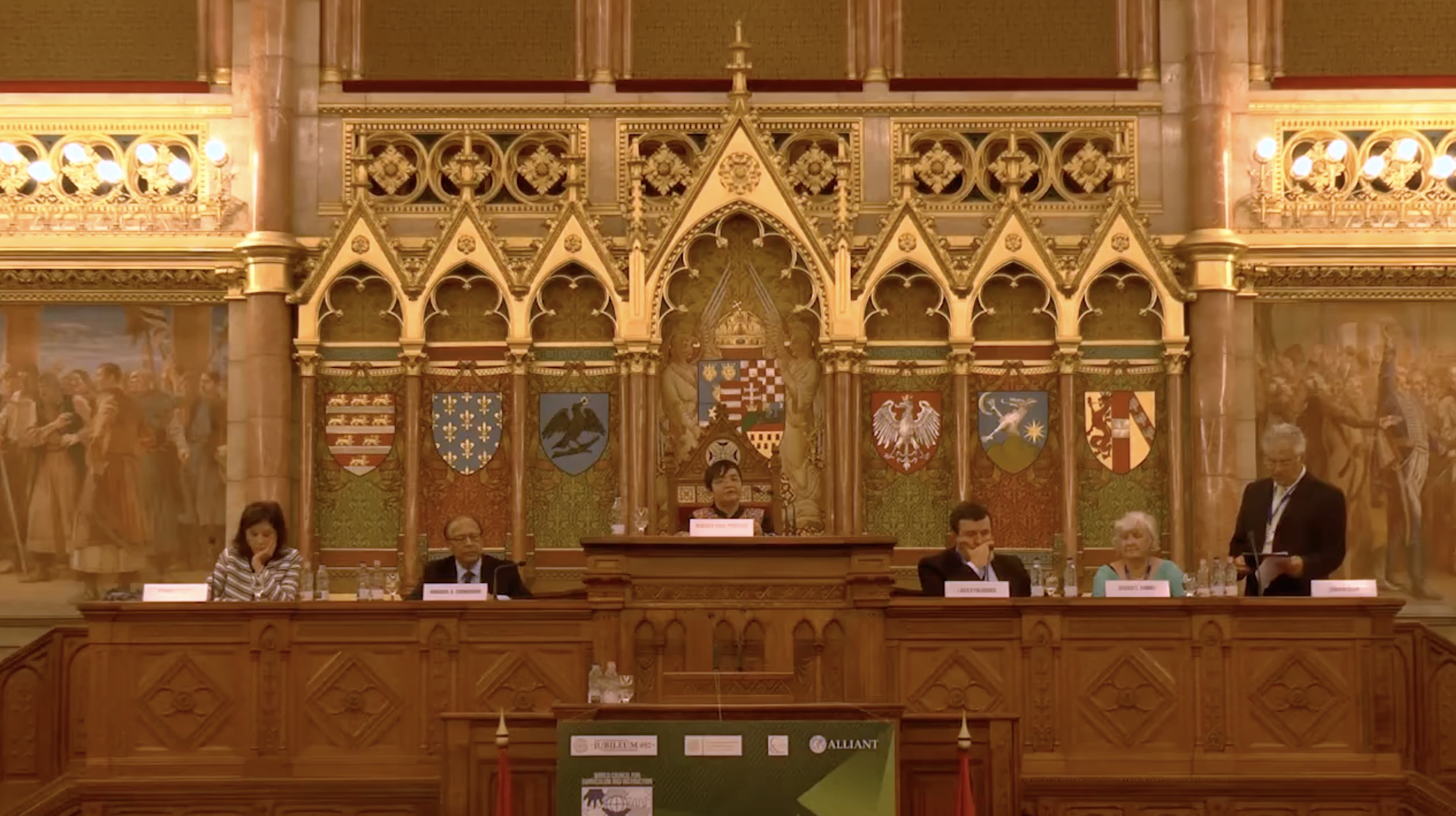 DJ facing a crowd at his deck. Photo with a purple hue